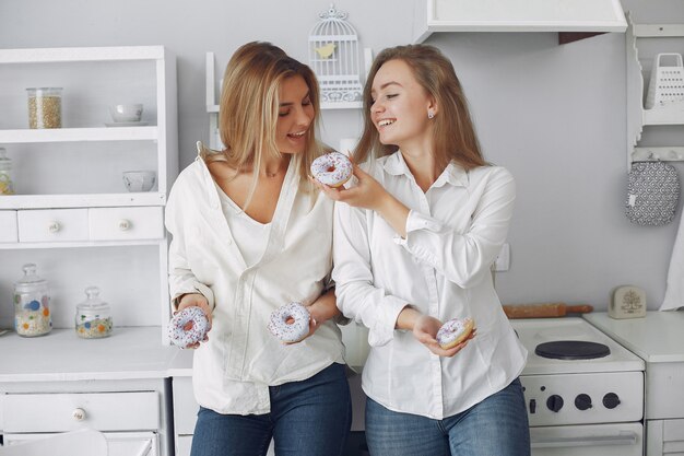 Hermosa mujer de pie en una cocina con donut