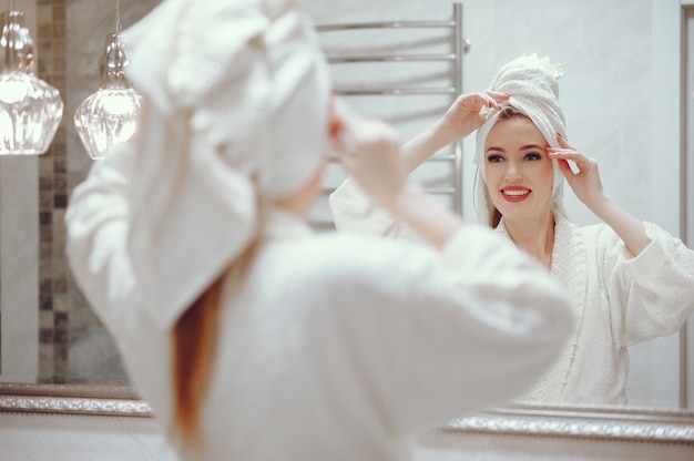 Hermosa mujer de pie en un cuarto de baño