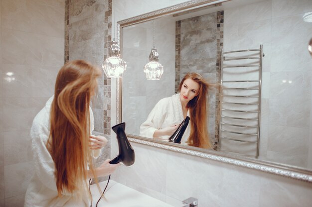 Hermosa mujer de pie en un cuarto de baño