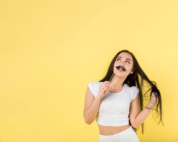 Hermosa mujer posando con bigote de papel