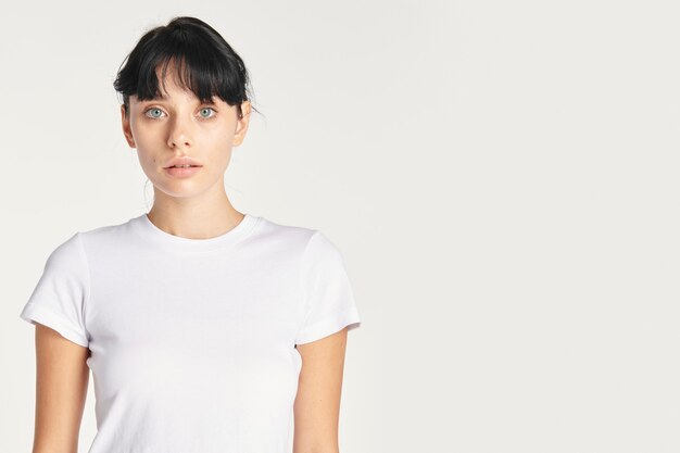 Hermosa mujer posando con camisa blanca en blanco, espacio de copia