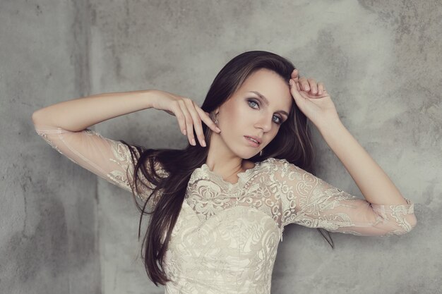 Hermosa mujer posando con elegante vestido blanco, concepto de moda