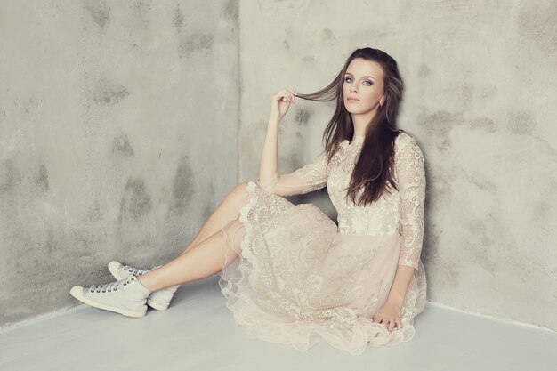 Hermosa mujer posando con elegante vestido blanco