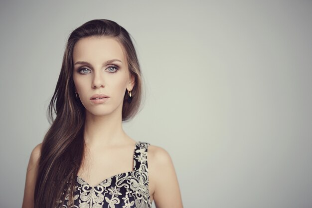 Hermosa mujer posando con elegante vestido negro, concepto de moda