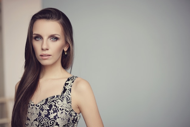 Hermosa mujer posando con elegante vestido negro, concepto de moda