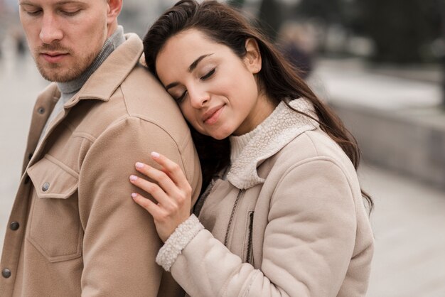 Hermosa mujer posando con hombre afuera