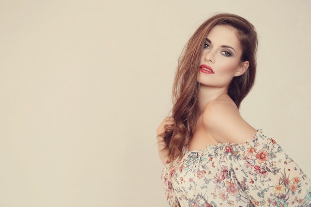 Hermosa mujer posando con vestido de flores, concepto de moda