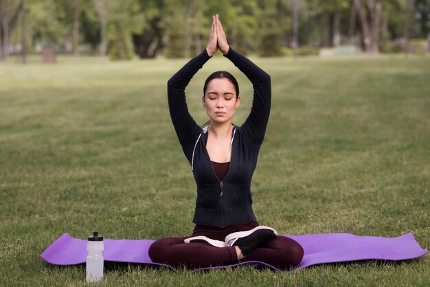 Hermosa mujer practicando yoga al aire libre