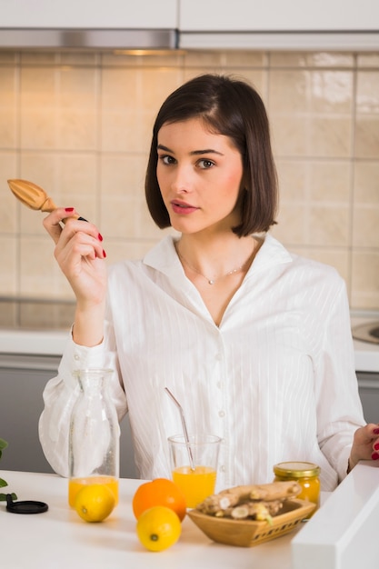 Hermosa mujer preparando jugo de naranja