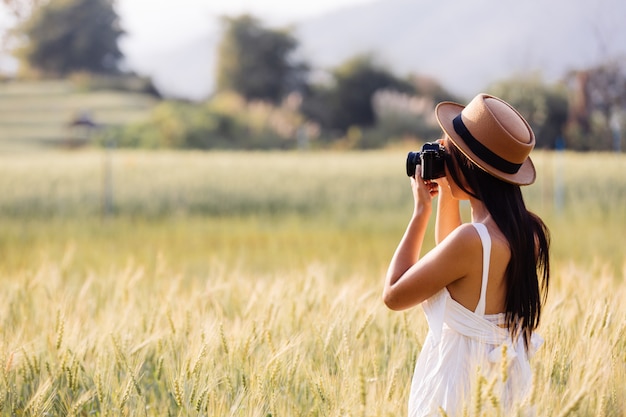 Una hermosa mujer que disfruta disparando en campos de cebada.