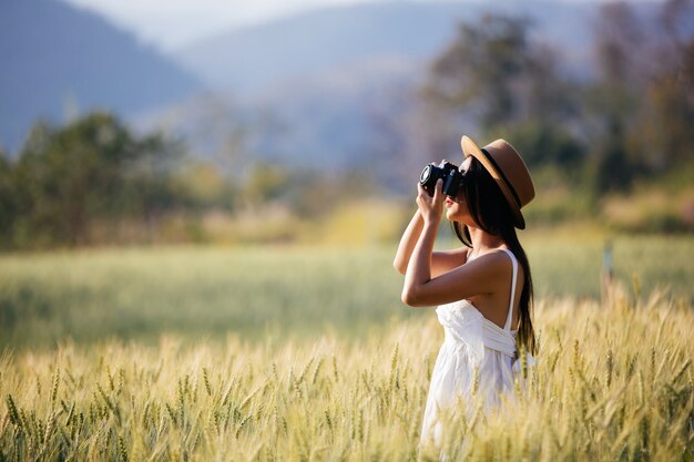 Una hermosa mujer que disfruta disparando en campos de cebada.