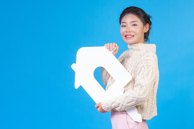 Una hermosa mujer que llevaba una nueva camisa blanca de manga larga con el símbolo de una casa. Comercio de la casa.