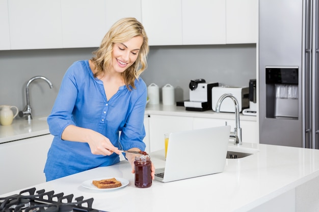 Hermosa mujer que se prepara una rebanada de pan