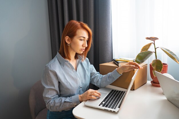 Hermosa mujer que trabaja en la computadora portátil, área de trabajo compartido