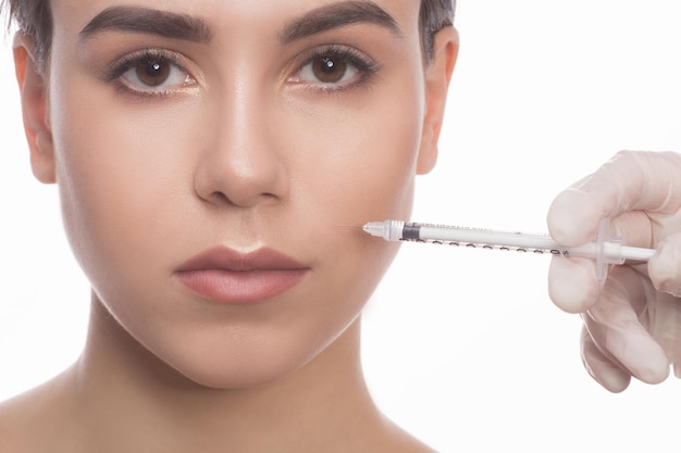 Hermosa mujer recibiendo inyecciones faciales de belleza. Inyección de envejecimiento facial.