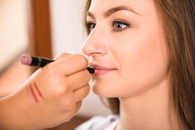 Hermosa mujer recibiendo maquillaje del artista