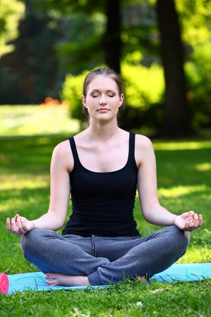 Hermosa mujer relajante en pose de yoga