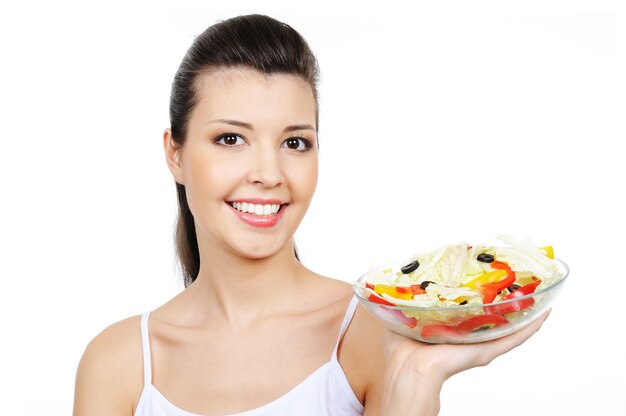 Hermosa mujer riendo alegre sosteniendo el plato con verduras