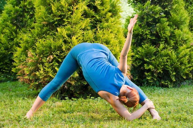 Hermosa mujer roja haciendo ejercicios de fitness o yoga