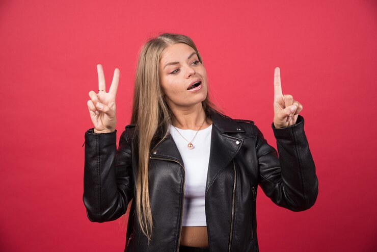 Foto gratuito una hermosa mujer con ropa casual mirando a la cámara y mostrando los dedos