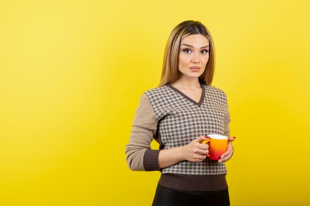 Hermosa mujer en ropa casual sosteniendo una taza de té.