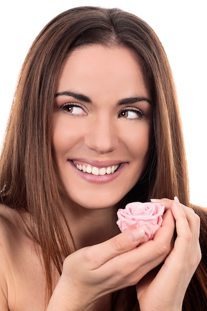 Hermosa mujer con rosa rosa sobre fondo blanco.