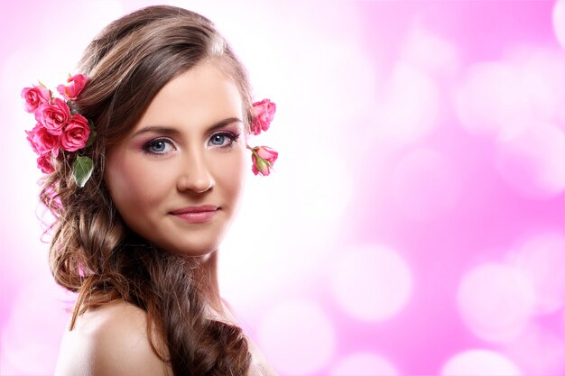 Hermosa mujer con rosas en el cabello