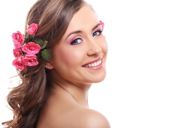 Hermosa mujer con rosas en el cabello