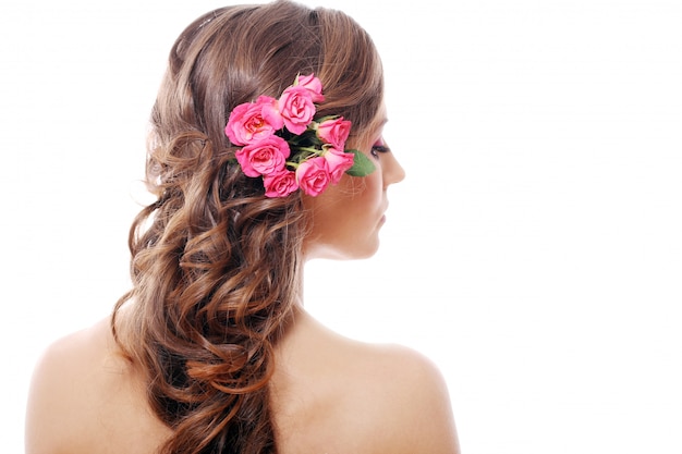 Foto gratuita hermosa mujer con rosas en el cabello