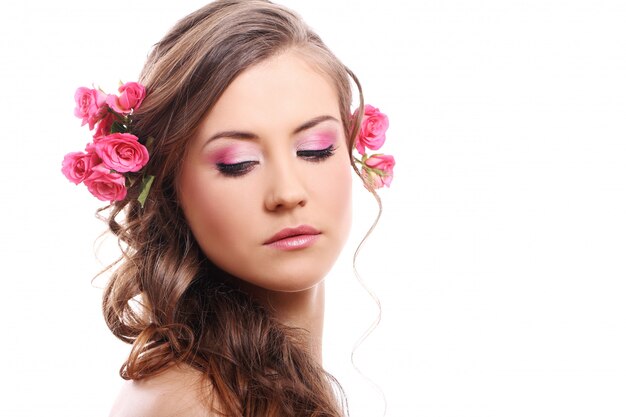 Hermosa mujer con rosas en el cabello