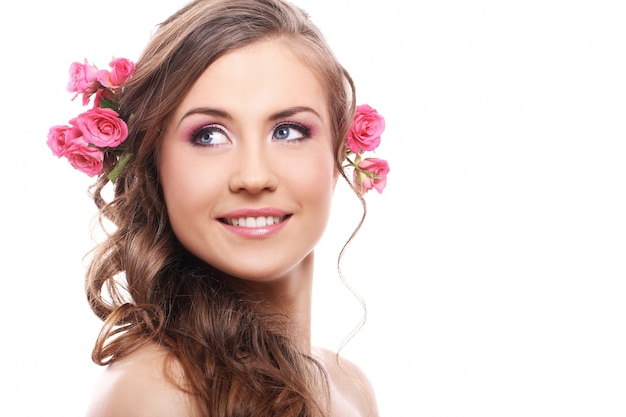 Hermosa mujer con rosas en el cabello