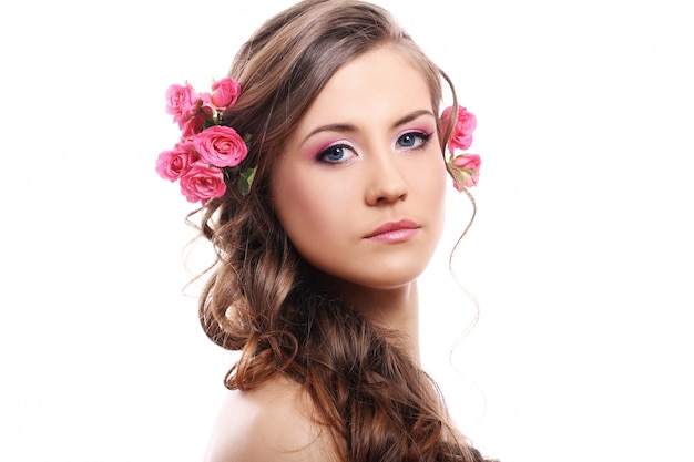 Hermosa mujer con rosas en el cabello