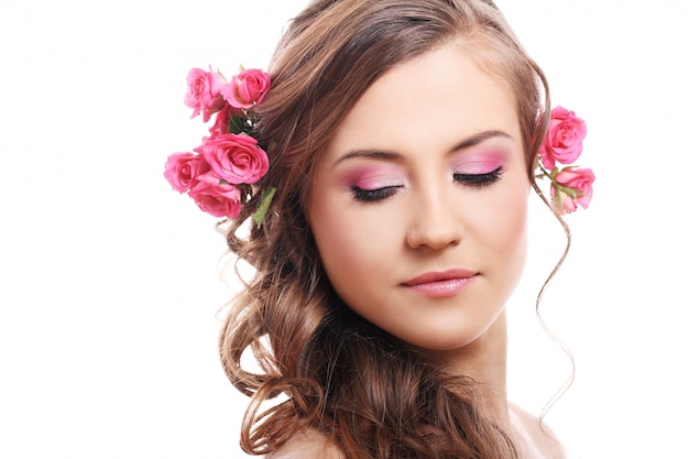 Hermosa mujer con rosas en el cabello