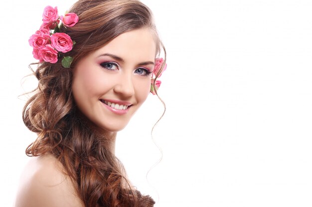 Hermosa mujer con rosas en el cabello