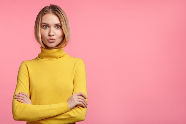 Hermosa mujer rubia con cuello alto amarillo