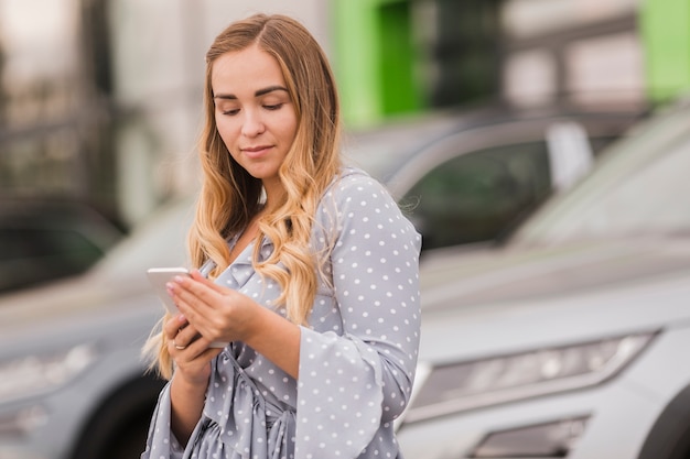 Foto gratuita hermosa mujer rubia mirando por teléfono