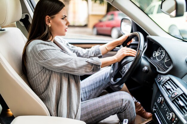 Hermosa mujer rubia pip en el coche en pánico con los ojos cerrados mientras conduce a alta velocidad.