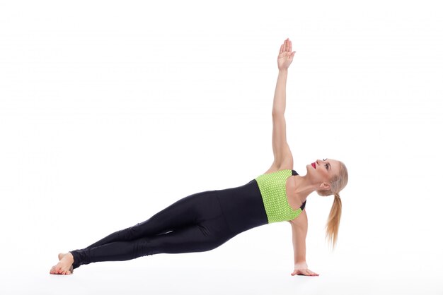 Hermosa mujer rubia practicando yoga aislado en blanco