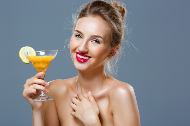 Foto gratuita hermosa mujer rubia sonriendo, sosteniendo cóctel