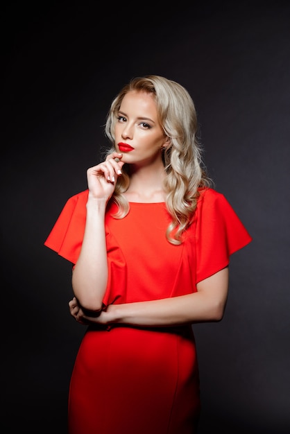 Hermosa mujer rubia en vestido de noche rojo