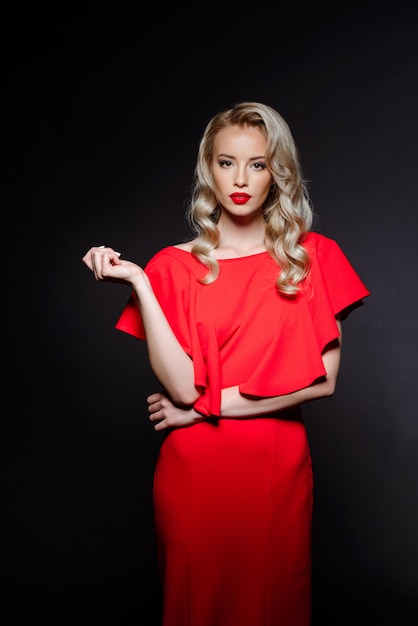 Hermosa mujer rubia en vestido de noche rojo