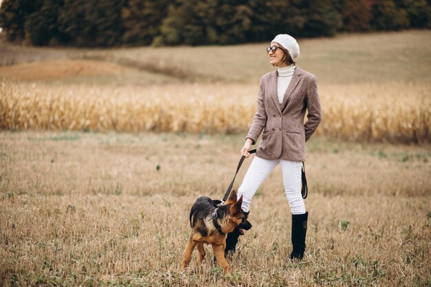 Hermosa mujer saliendo de su perro en un campo