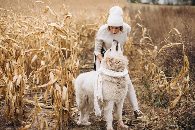 Hermosa mujer saliendo de su perro en un campo