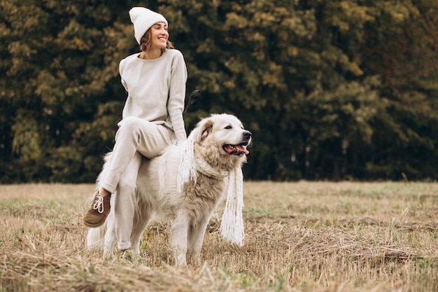 Hermosa mujer saliendo de su perro en un campo