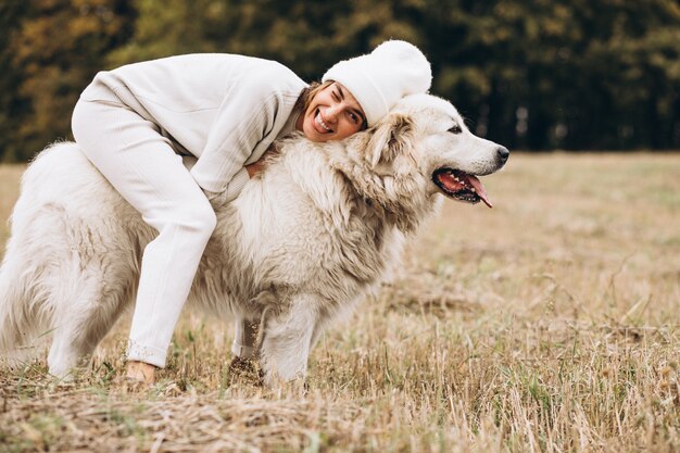 Hermosa mujer saliendo de su perro en un campo