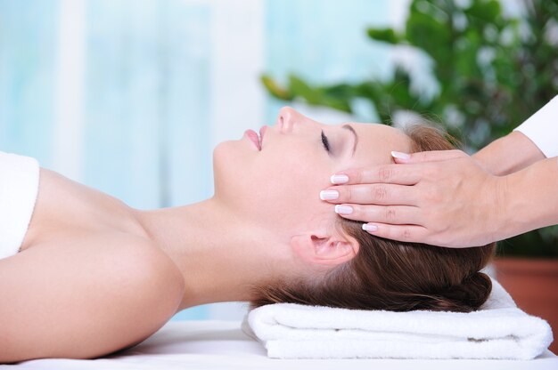 Hermosa mujer en el salón de belleza recibiendo un masaje facial