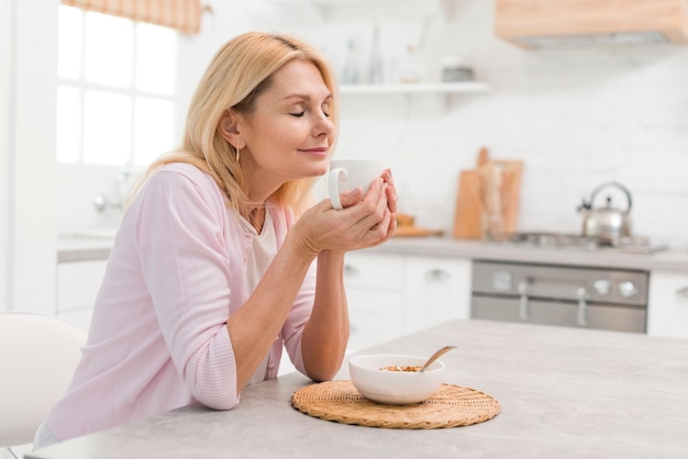 Hermosa mujer senior disfrutando del desayuno