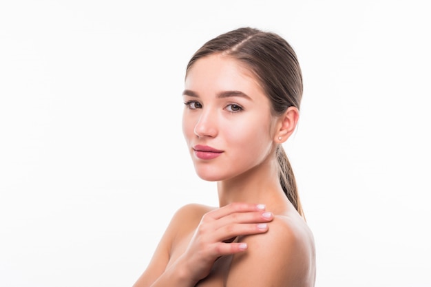 Hermosa mujer sensual tocando su rostro aislado en la pared blanca. Concepto de belleza y cuidado de la piel. Spa.