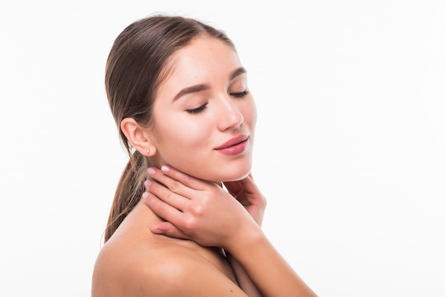 Hermosa mujer sensual tocando su rostro aislado en la pared blanca. Concepto de belleza y cuidado de la piel. Spa.