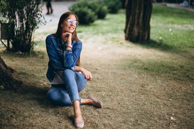 Hermosa mujer sentada ander un árbol